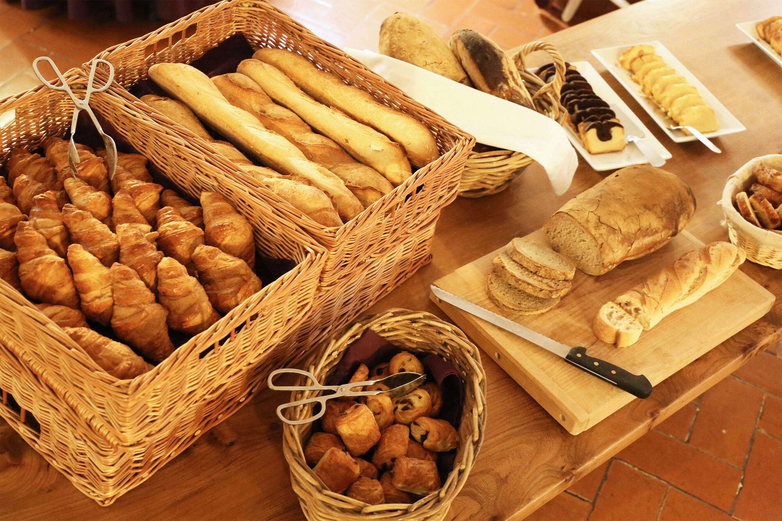 Une variété de pains et de viennoiseries présentés sur une table en bois.