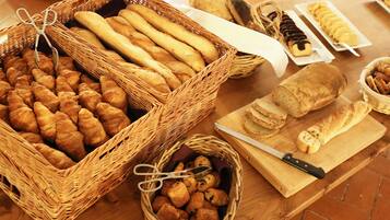 Une variété de pains et de viennoiseries présentés sur une table en bois.