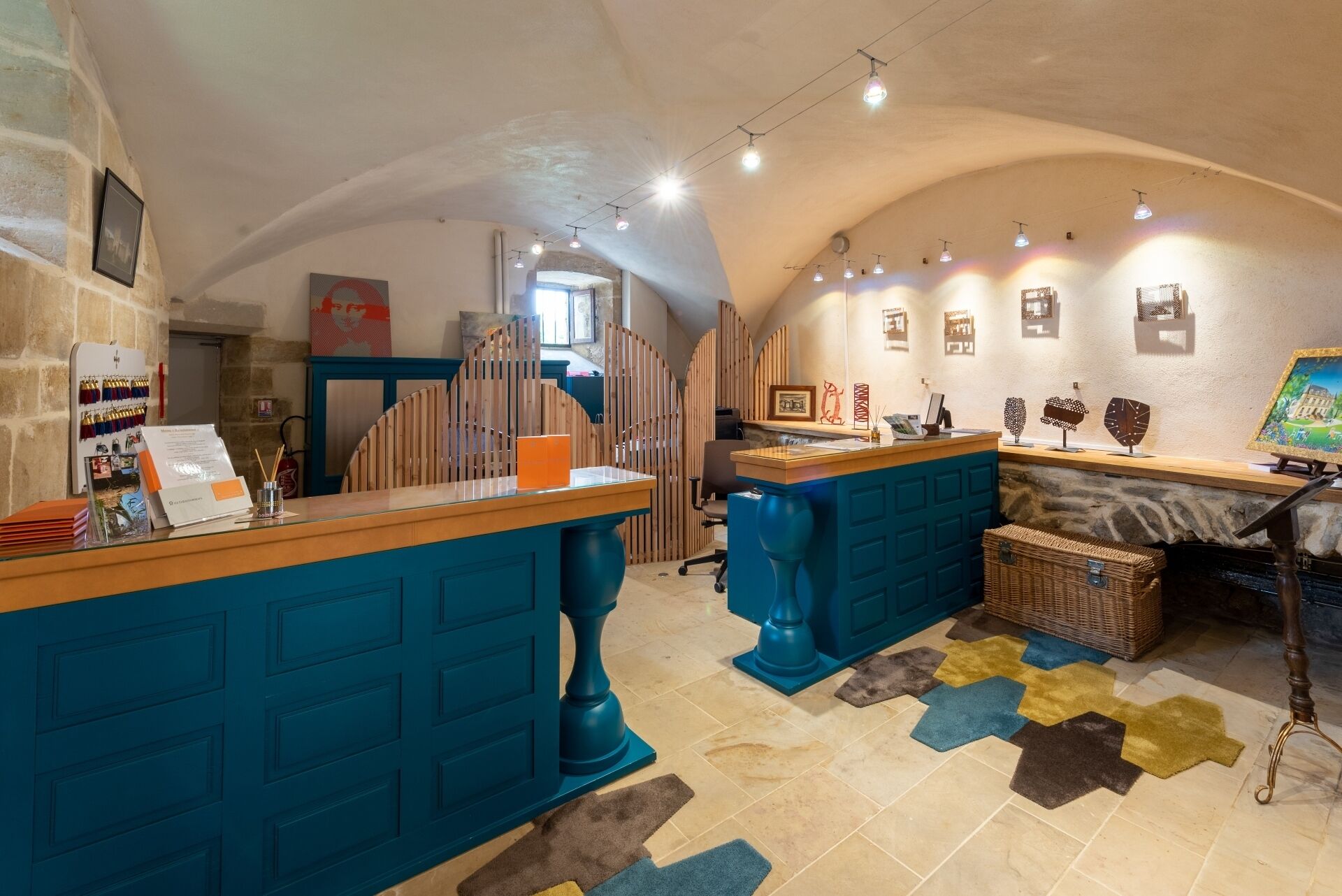 A reception area with a blue counter, a wooden reception desk, and a stone wall.