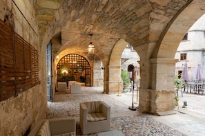 An indoor courtyard with stone arches, a seating area, and a view of the street. - Chateau des Ducs de Joyeuse, BW Signature Collection (Couiza)