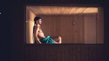 Una sala de sauna con paredes de madera y un reloj visible.