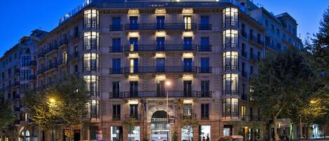 A multi-story hotel with a classic architectural style, featuring balconies and a central entrance.