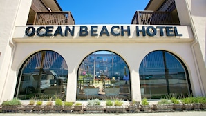 The exterior of the Ocean Beach Hotel with a clear view of the entrance and large arched windows. - Ocean Beach Hotel (San Diego)