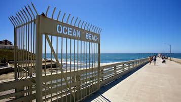 A pier with a sign reading "Ocean Beach" leading to the sea.