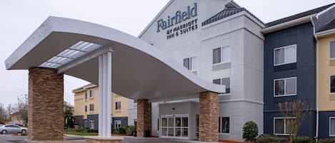 A Fairfield by Marriott Inn & Suites building with a modern design, featuring a covered entrance and multiple floors.