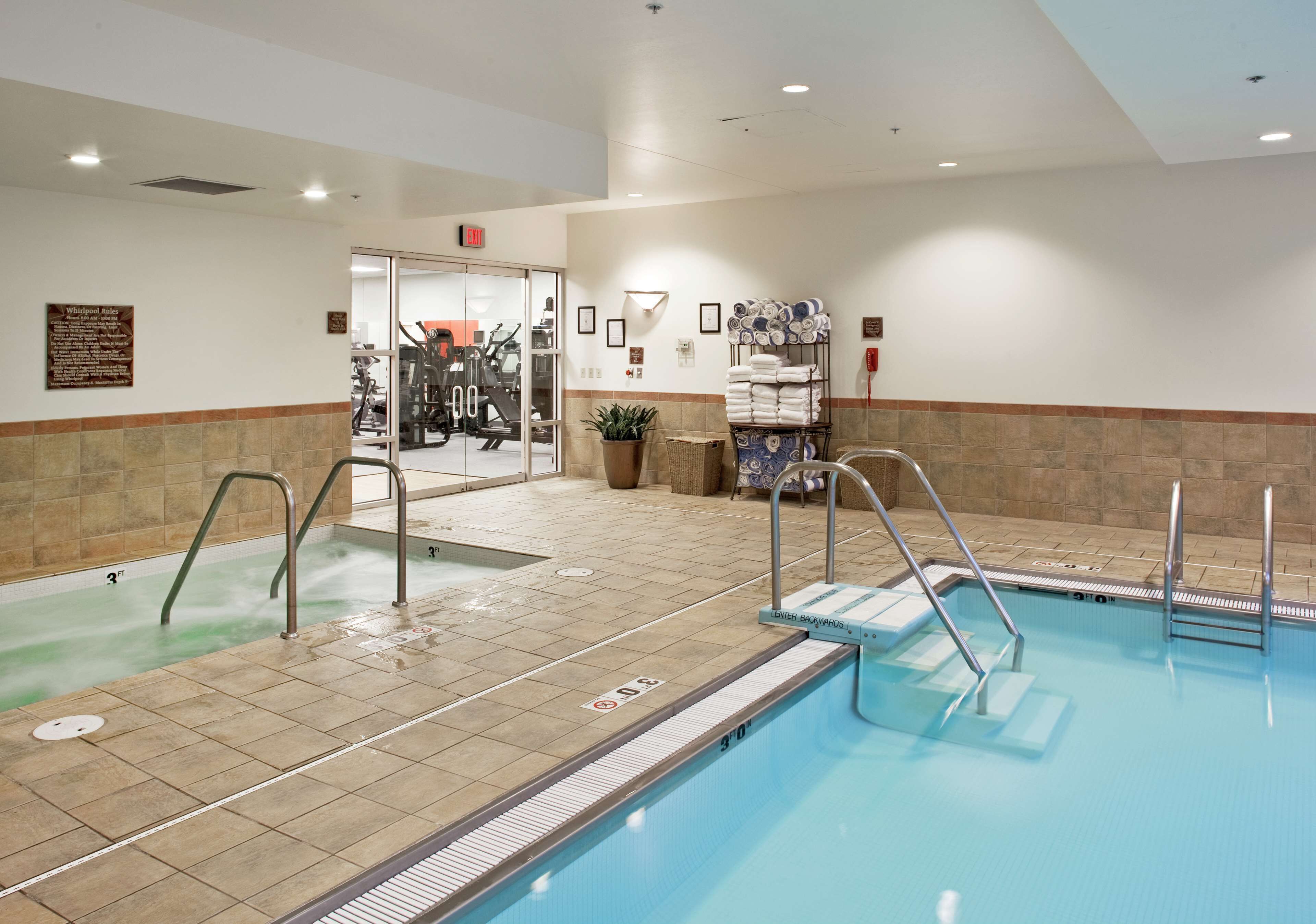 A swimming pool with multiple lanes, a fitness area, and a wall-mounted towel rack.