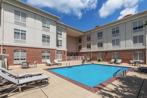 A pool area with lounge chairs and a brick building. - Holiday Inn Express & Suites Vicksburg by IHG (Vicksburg)