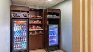 A vending machine area with Coca-Cola Ice Cold and a Frozen Food machine.