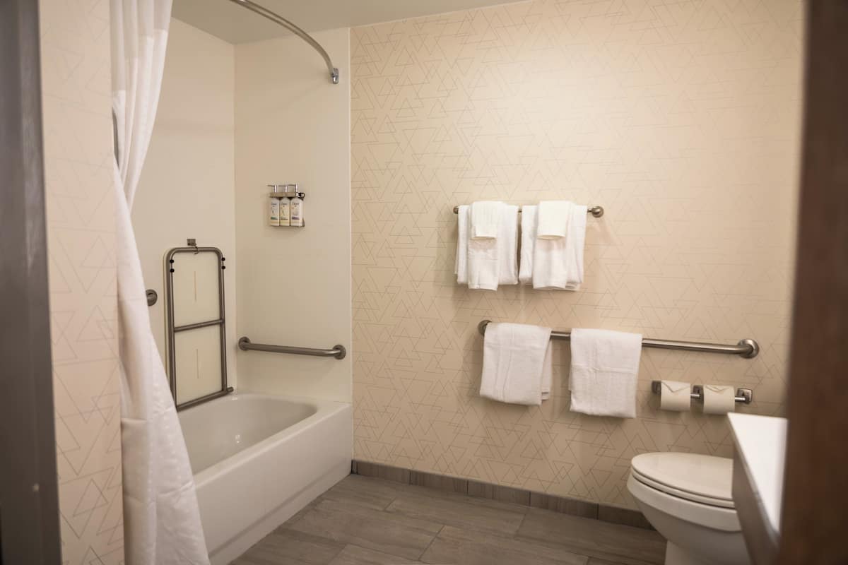 A bathroom with a bathtub, toilet, and towel rack.