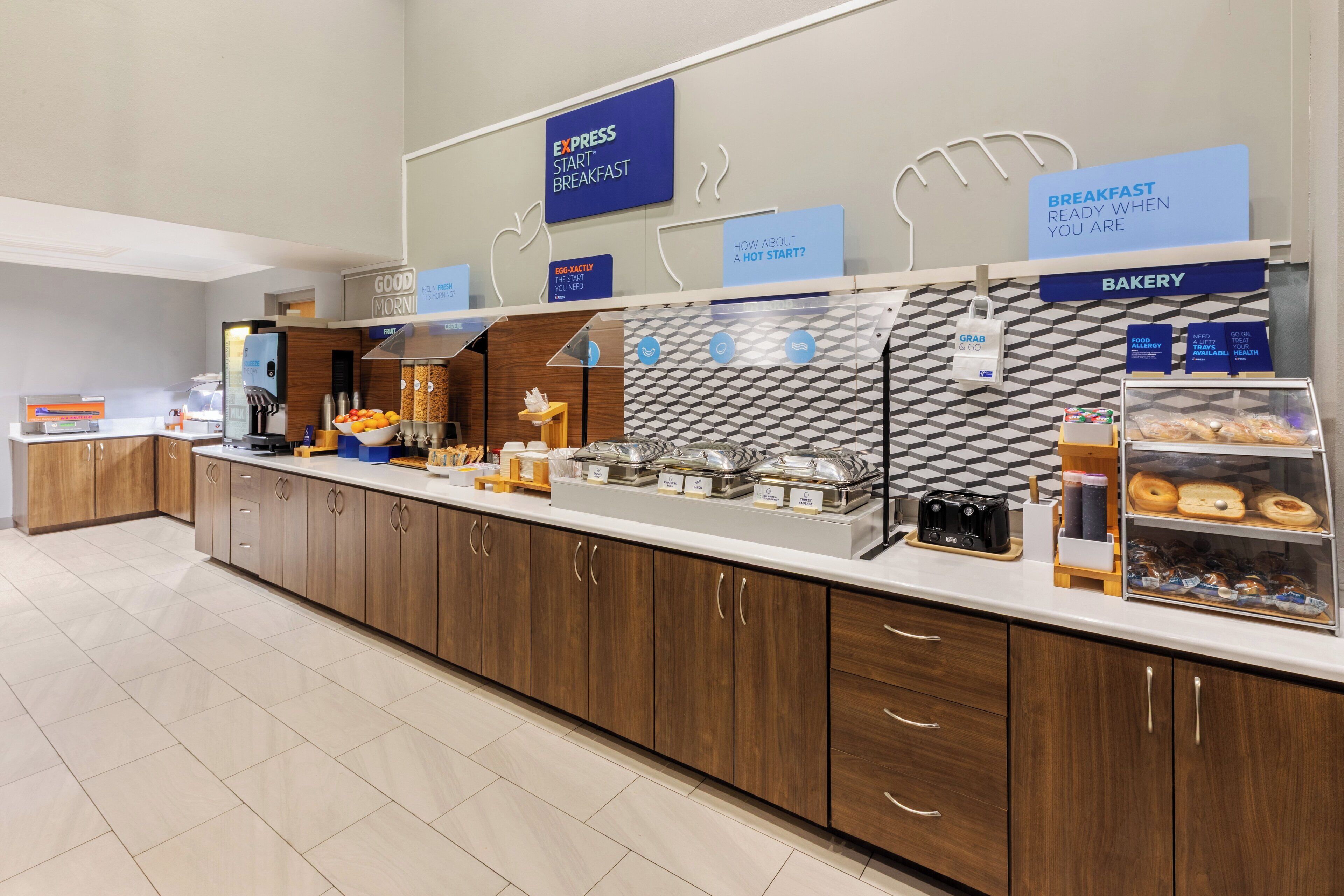 A breakfast buffet area with various food options and a bakery section.
