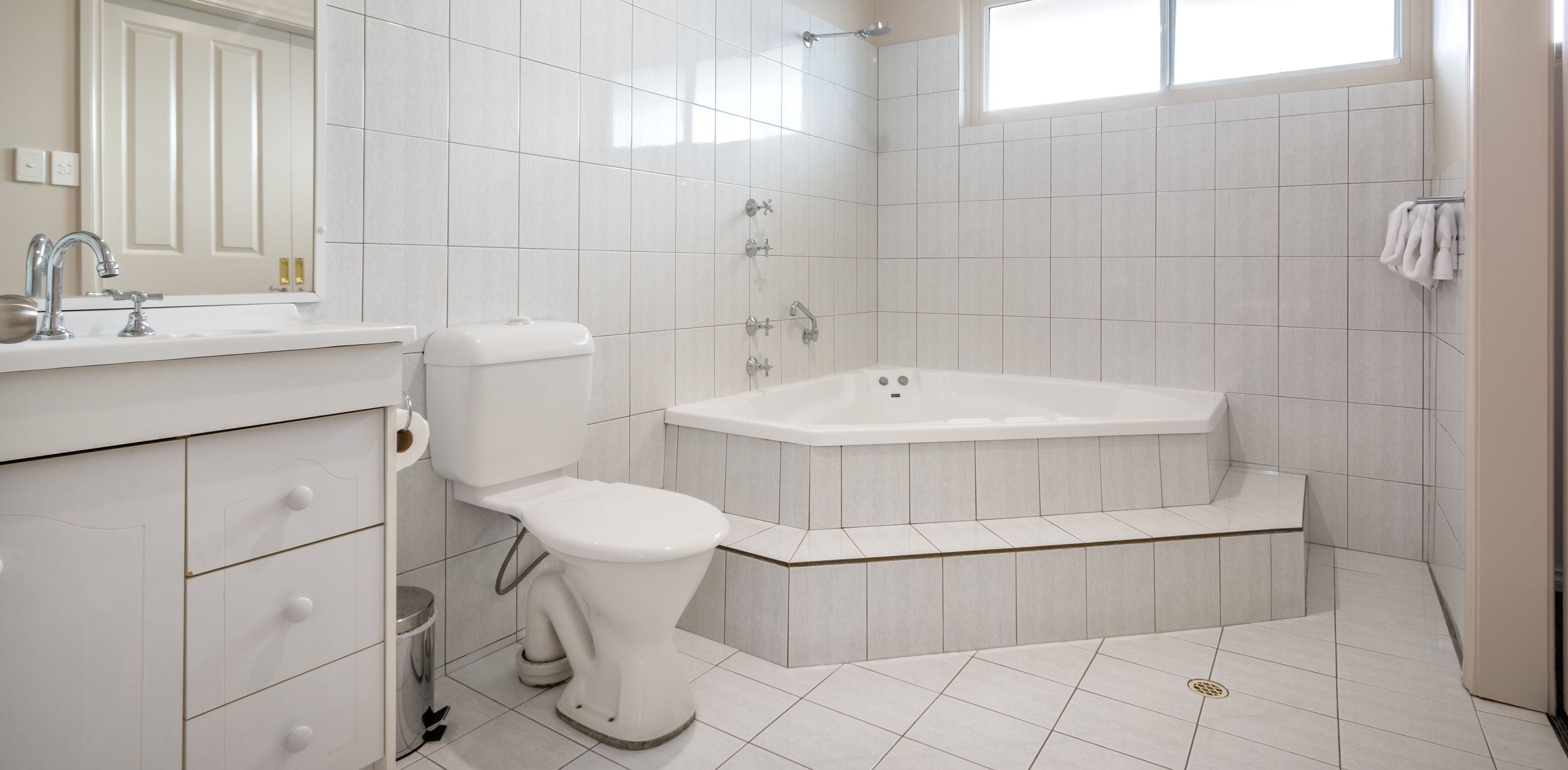 A modern bathroom with a toilet, sink, and bathtub.