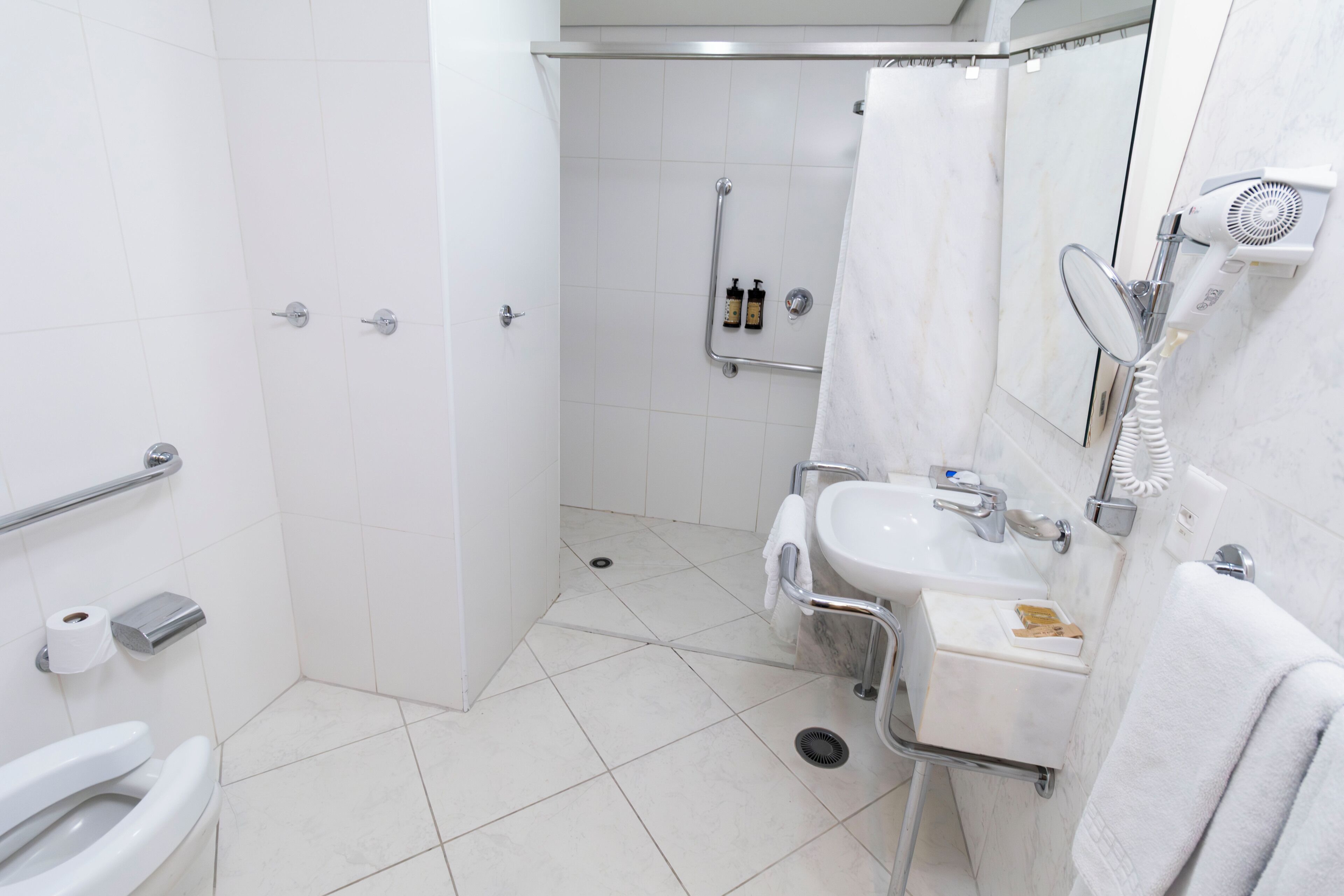 Un bagno moderno con il water, lavandino e zona doccia.