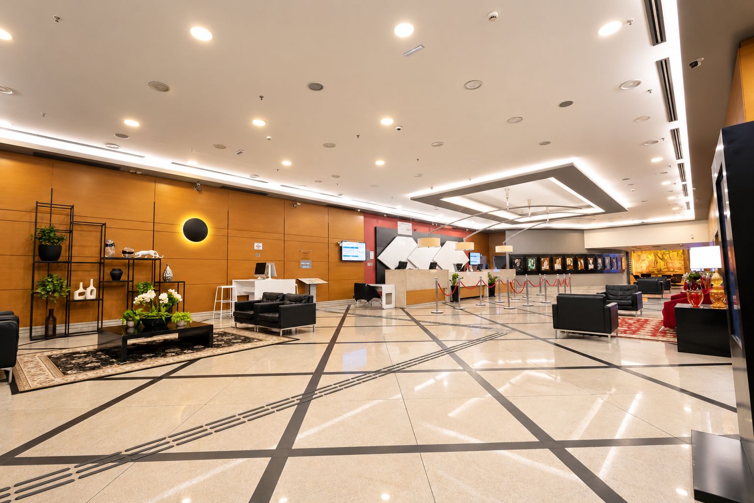 Un moderno vestíbulo de hotel con mostrador de recepción, zona de estar y una gran pared con obras de arte.