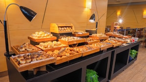 A buffet with various baked goods and a wooden counter. - Hotel Nacional Inn Jaragua São Paulo (São Paulo)