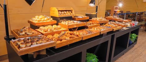 A buffet with various baked goods and a wooden counter.