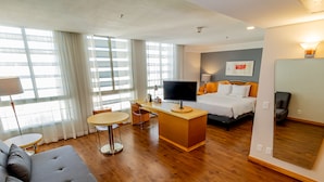 A hotel room with a bed, a desk with a TV, a sofa, and a dining table. - Hotel Nacional Inn Jaragua São Paulo (São Paulo)