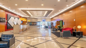 A spacious lobby with a reception desk, seating area, and a television screen. - Hotel Nacional Inn Jaragua São Paulo (São Paulo)