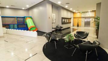 Relax and play in our welcoming lobby, featuring a play area, seating space, and lush greenery.