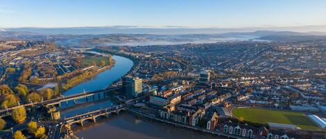 Vista aérea de una ciudad con un río, puentes y una mezcla de edificios residenciales y comerciales.