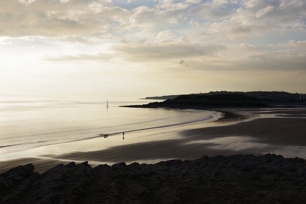 A coastal landscape with a calm sea, rocky shoreline, and a distant hill. - Holiday Inn Express Newport by IHG (Newport)