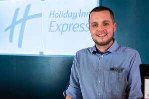 A man in a blue checkered shirt standing in front of a sign that reads "Holiday Inn Express." - Holiday Inn Express Newport by IHG (Newport)