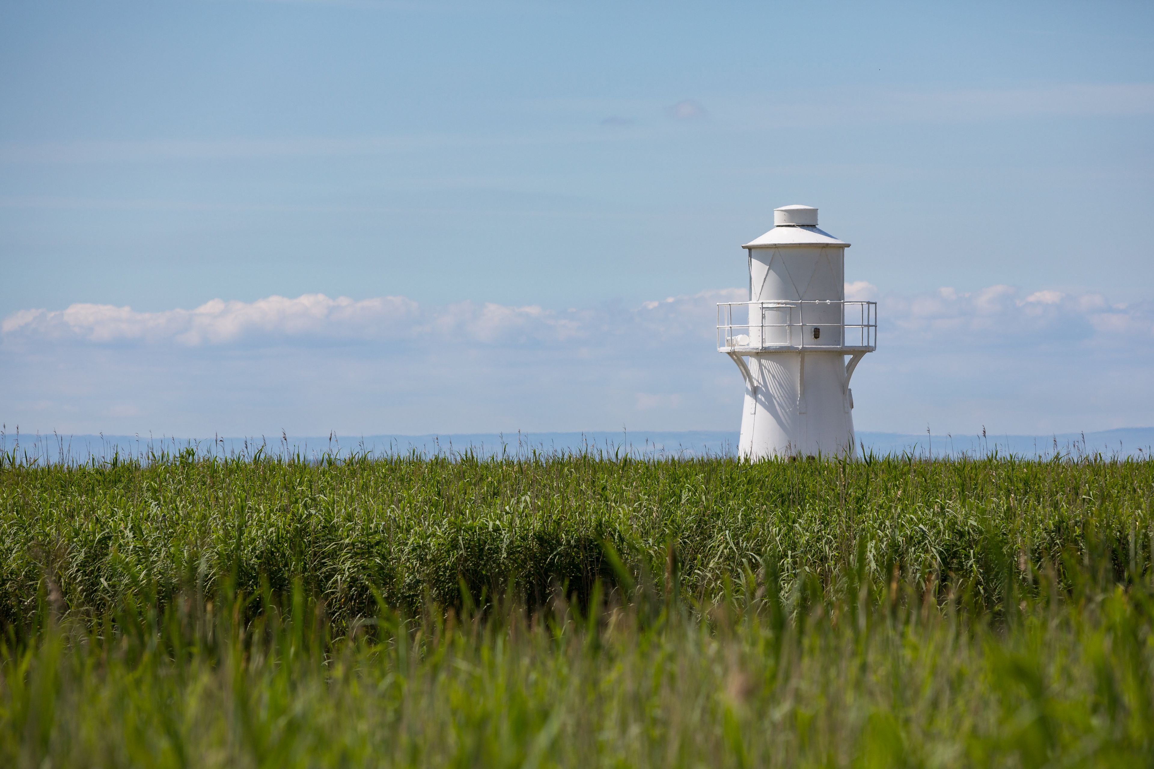 Un faro en un campo con cielo despejado.