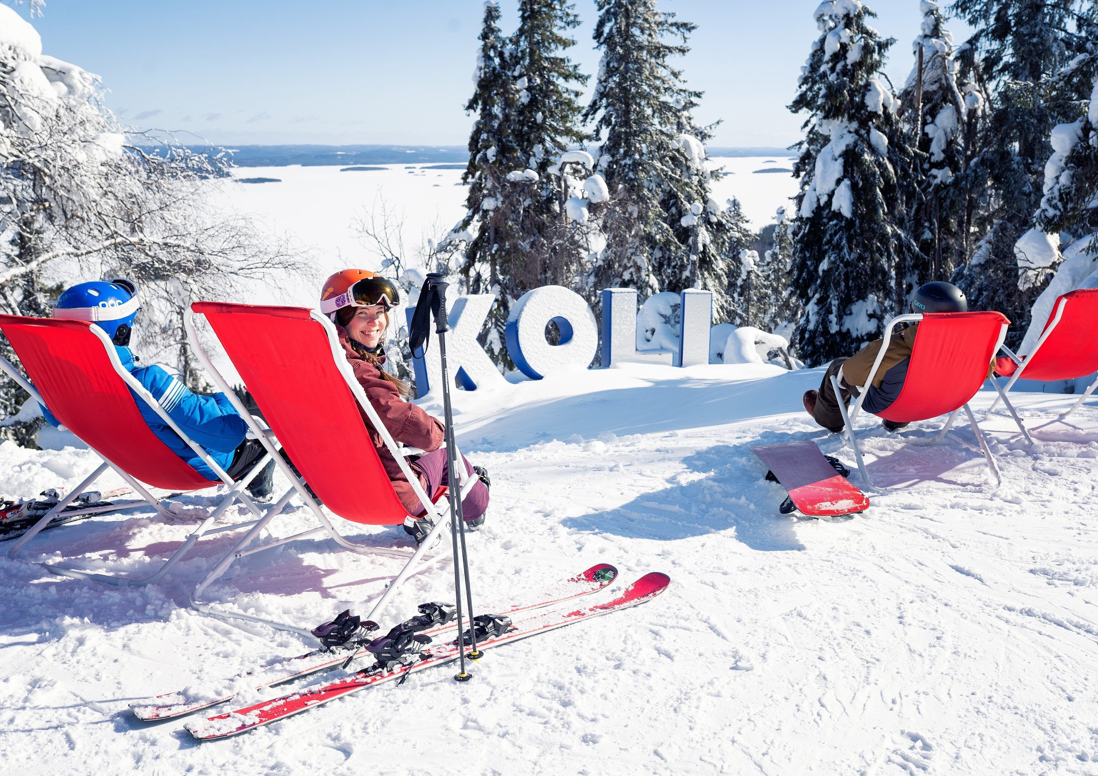A ski resort with red chairs and skis in the snow.