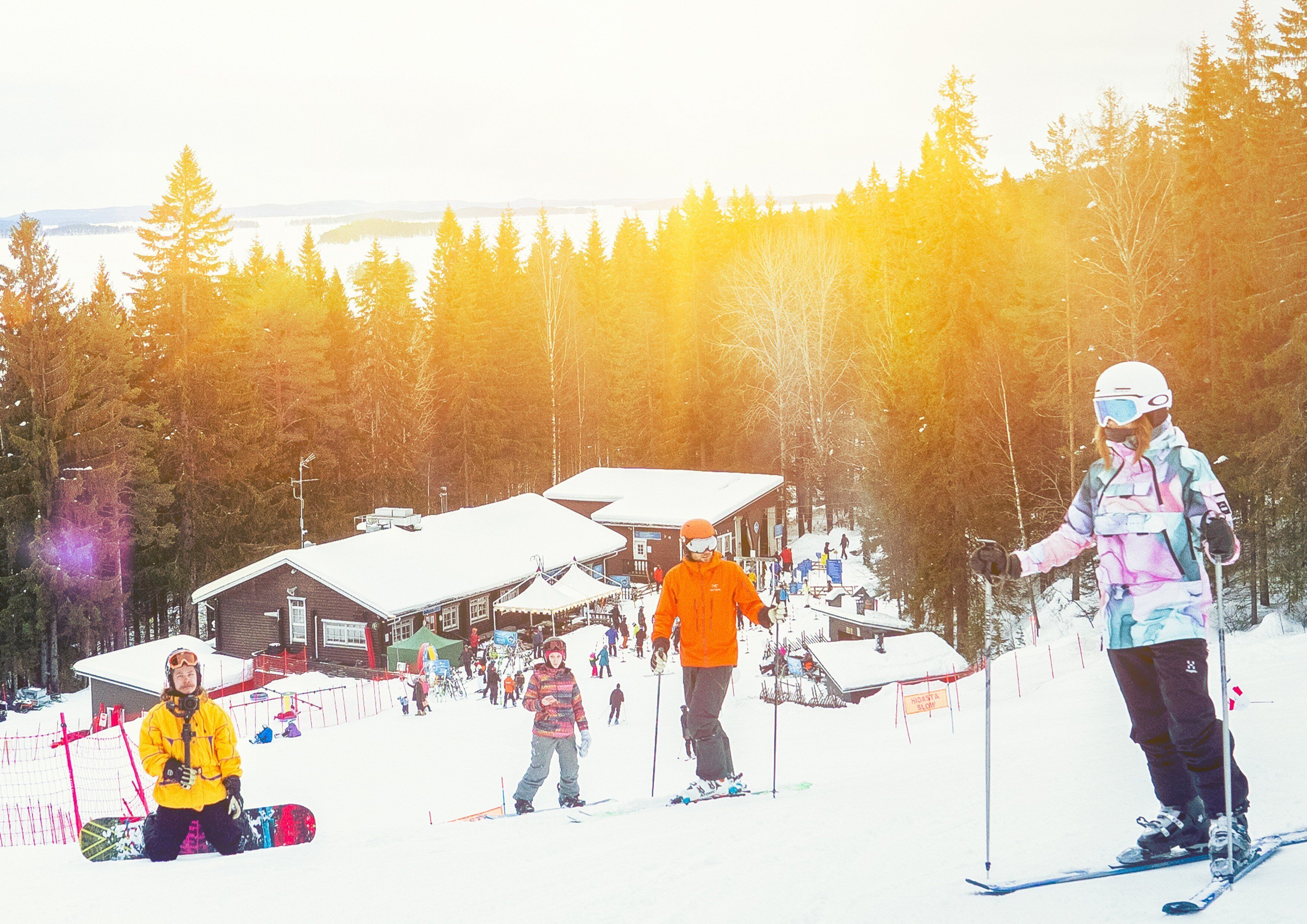 A ski resort with cabins, a ski slope, and a forested backdrop.