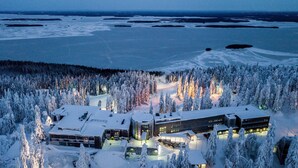 A snow-covered lodge with multiple buildings, surrounded by dense forests and a frozen lake. - Break Sokos Hotel Koli (Lieksa)
