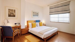 Un dormitorio con una cama de madera, un escritorio, una silla y dos mesitas de noche con lámparas.