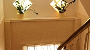 A staircase with a red carpet, two potted plants on the landing, and a window with a view of the outside. - Haus Sparkuhl Hotel Garni (Hannover)
