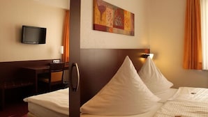 A hotel room with a bed, a desk, a television, and a painting on the wall. - Haus Sparkuhl Hotel Garni (Hannover)