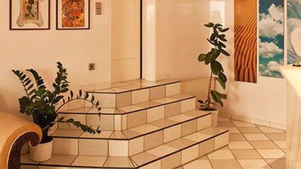 A modern interior with a staircase, a potted plant, and artwork on the walls. - Haus Sparkuhl Hotel Garni (Hannover)