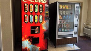 Una macchina distributrice di Coca-Cola e altre bevande, e una macchina distributrice di snack accanto.