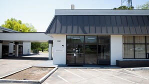 Un edificio moderno con la segnaletica della reception, ampie finestre e un parcheggio.