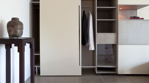 A modern interior with a wardrobe, a statue, and a table.