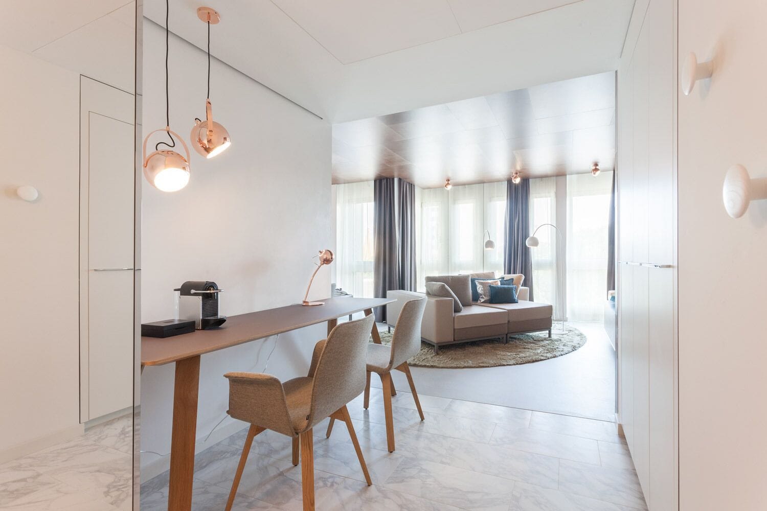 Uma sala de estar moderna com sofá, mesa de centro e área de jantar com mesa e cadeiras.
