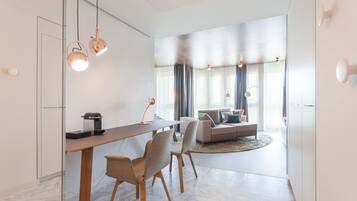 Uma sala de estar moderna com sofá, mesa de centro e área de jantar com mesa e cadeiras.