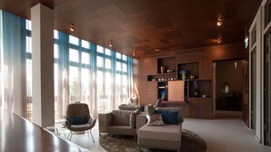 Una sala de estar moderna con ventanas amplias, una chimenea y un rincón de descanso acogedor.
