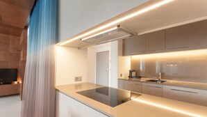 Una cocina moderna con estufa integrada, gabinetes de acero inoxidable e iluminación debajo de los armarios.