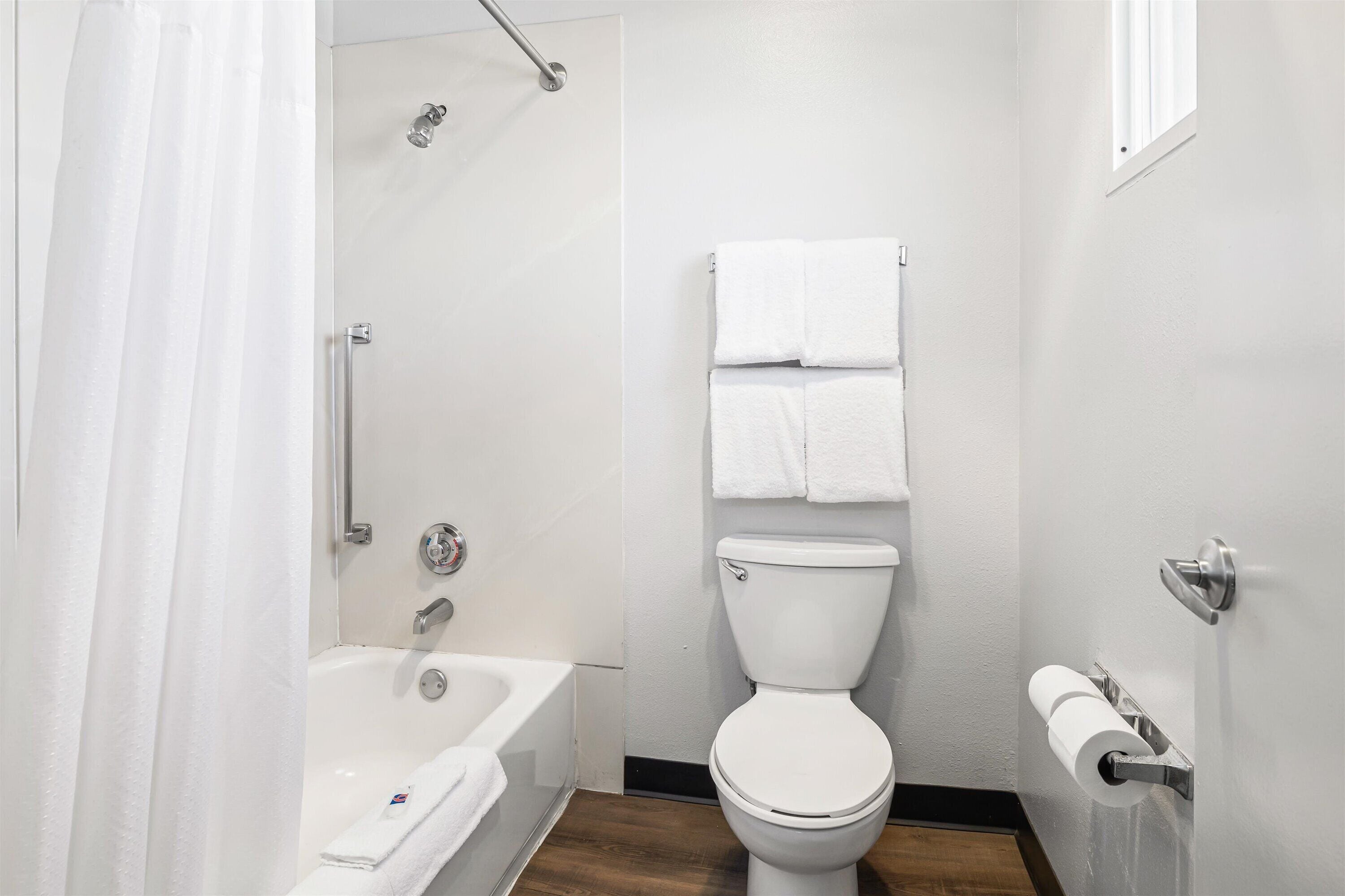 A bathroom with a bathtub, toilet, and shower.