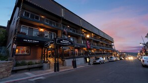 Un hotel de varios pisos con balcones, un cartel que dice 'Treasure Mountain Inn' y una bandera.