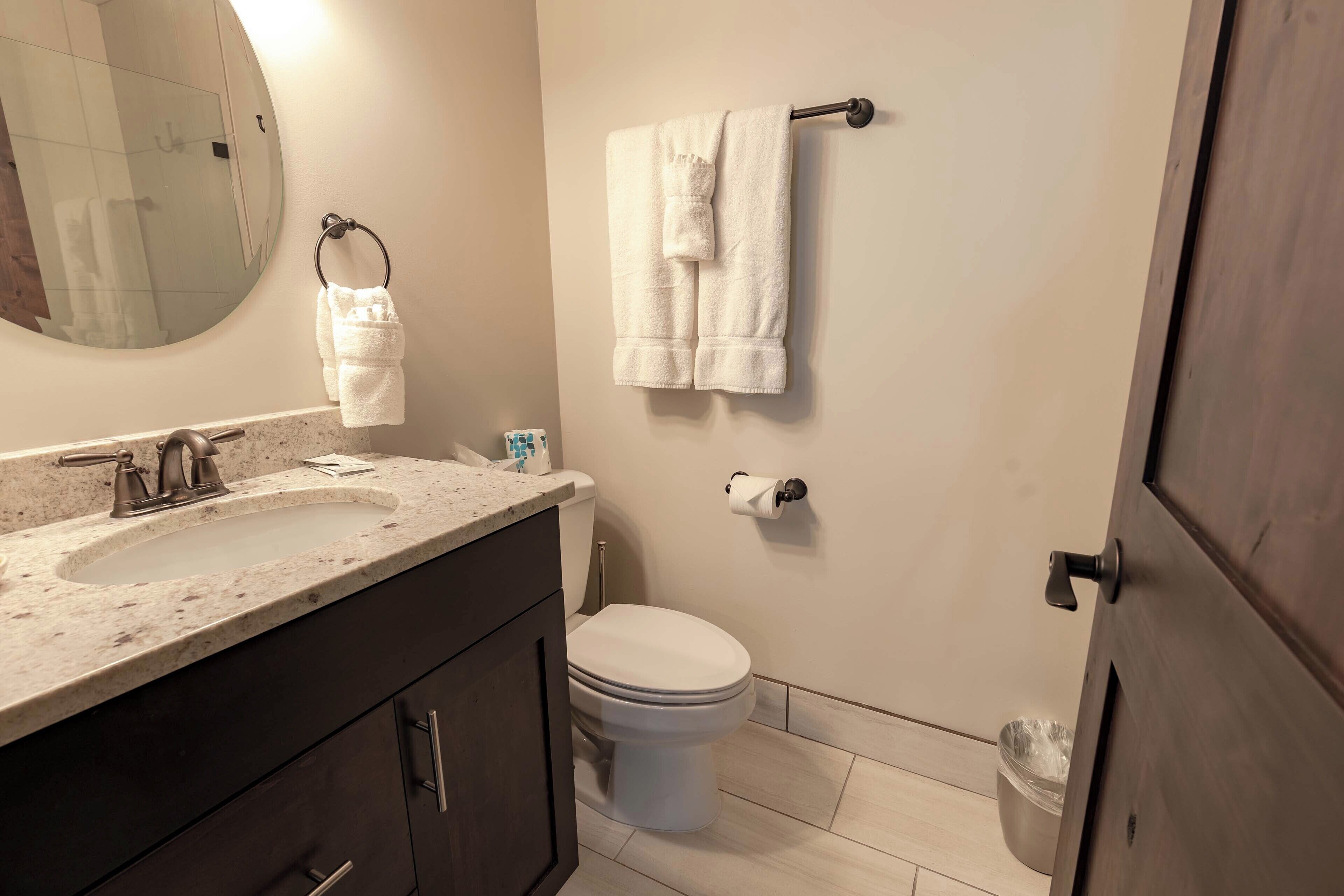 A bathroom with a sink, toilet, and towel rack.
