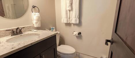 A bathroom with a sink, toilet, and towel rack.