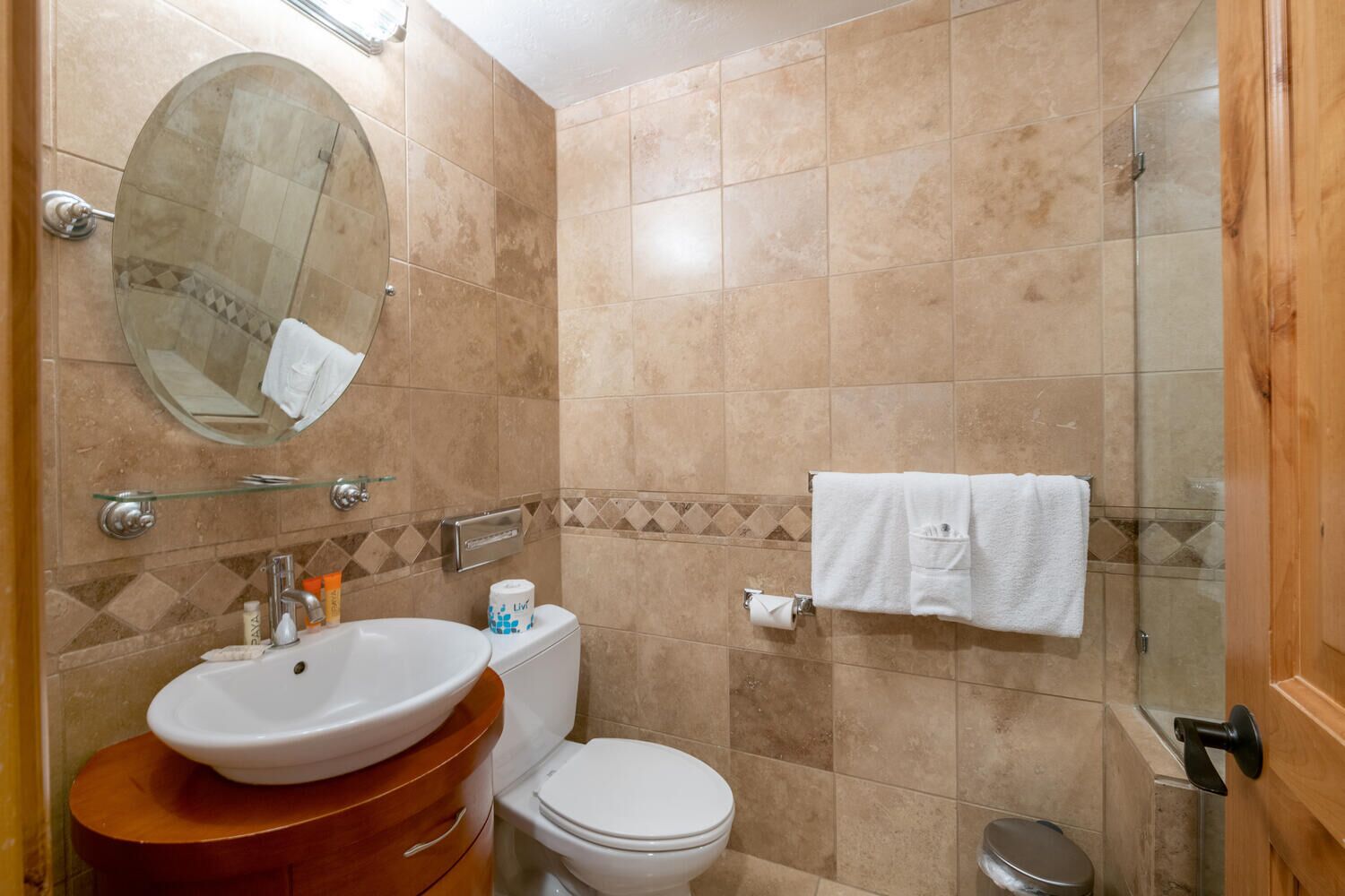 Une salle de bain équipée d’un lavabo, d’un miroir, de toilettes et d’une douche.