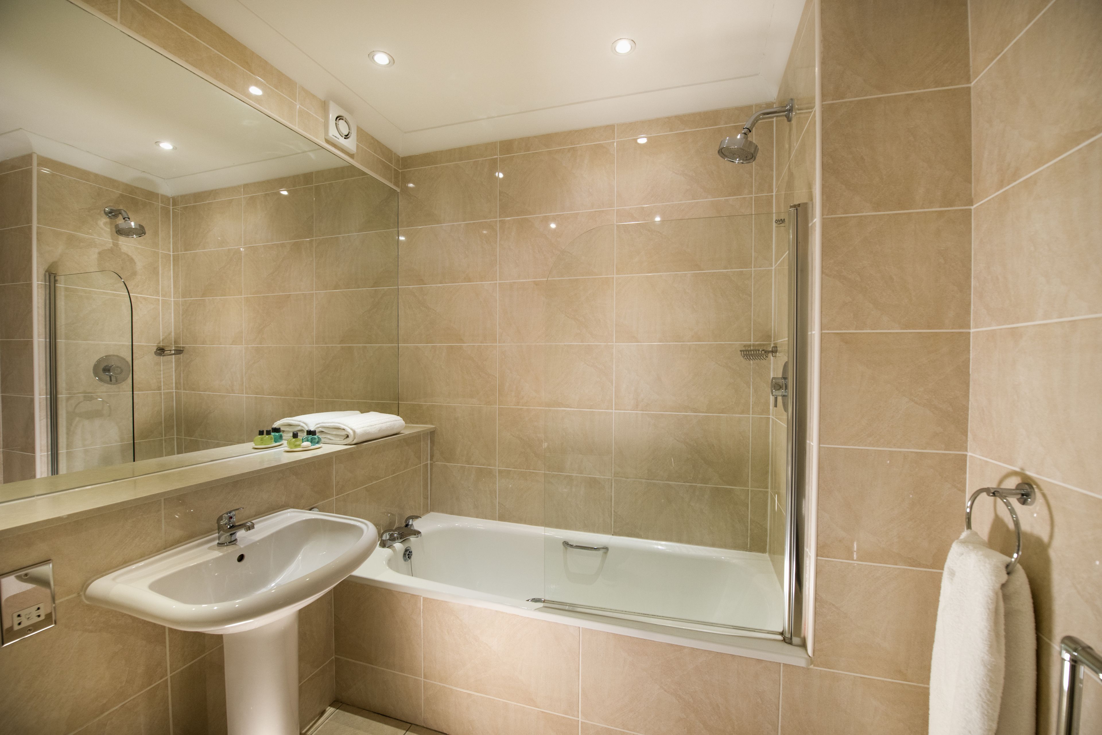 A modern bathroom with a bathtub, a sink, and a glass-enclosed shower.