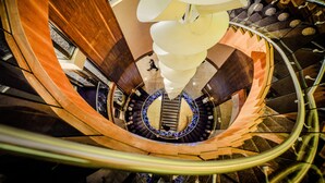 Una escalera de caracol con una columna central y una lámpara decorativa.