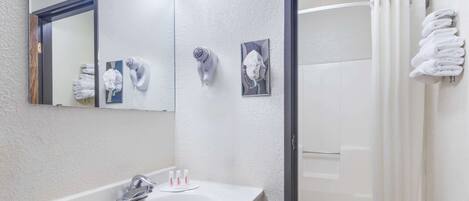 A bathroom with a white sink, a mirror, and a shower curtain.