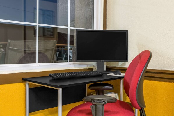Un escritorio con monitor, teclado y silla.