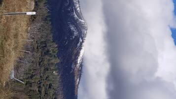 A mountainous landscape with a road and a signpost.
